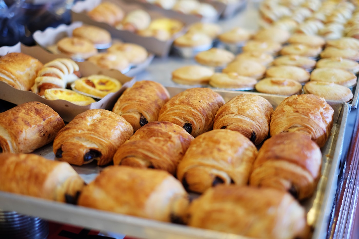 freshly baked cocoa pastries on stone table, beige and brown tones, luxury bakery atmosphere, no woman